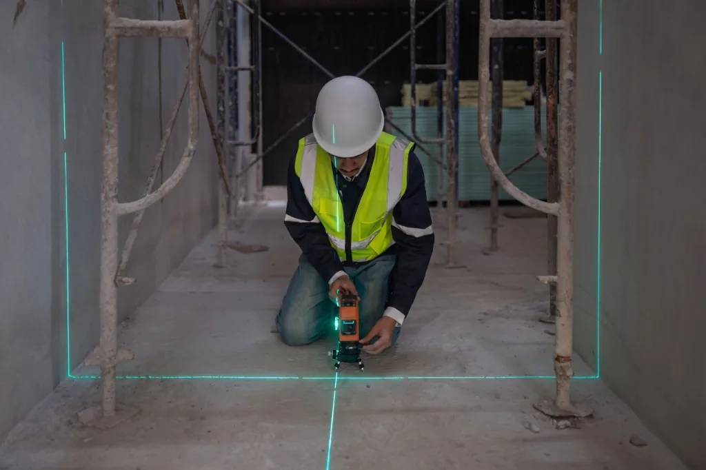 Engenheiro inspecionando nivelamento e prumo na obra